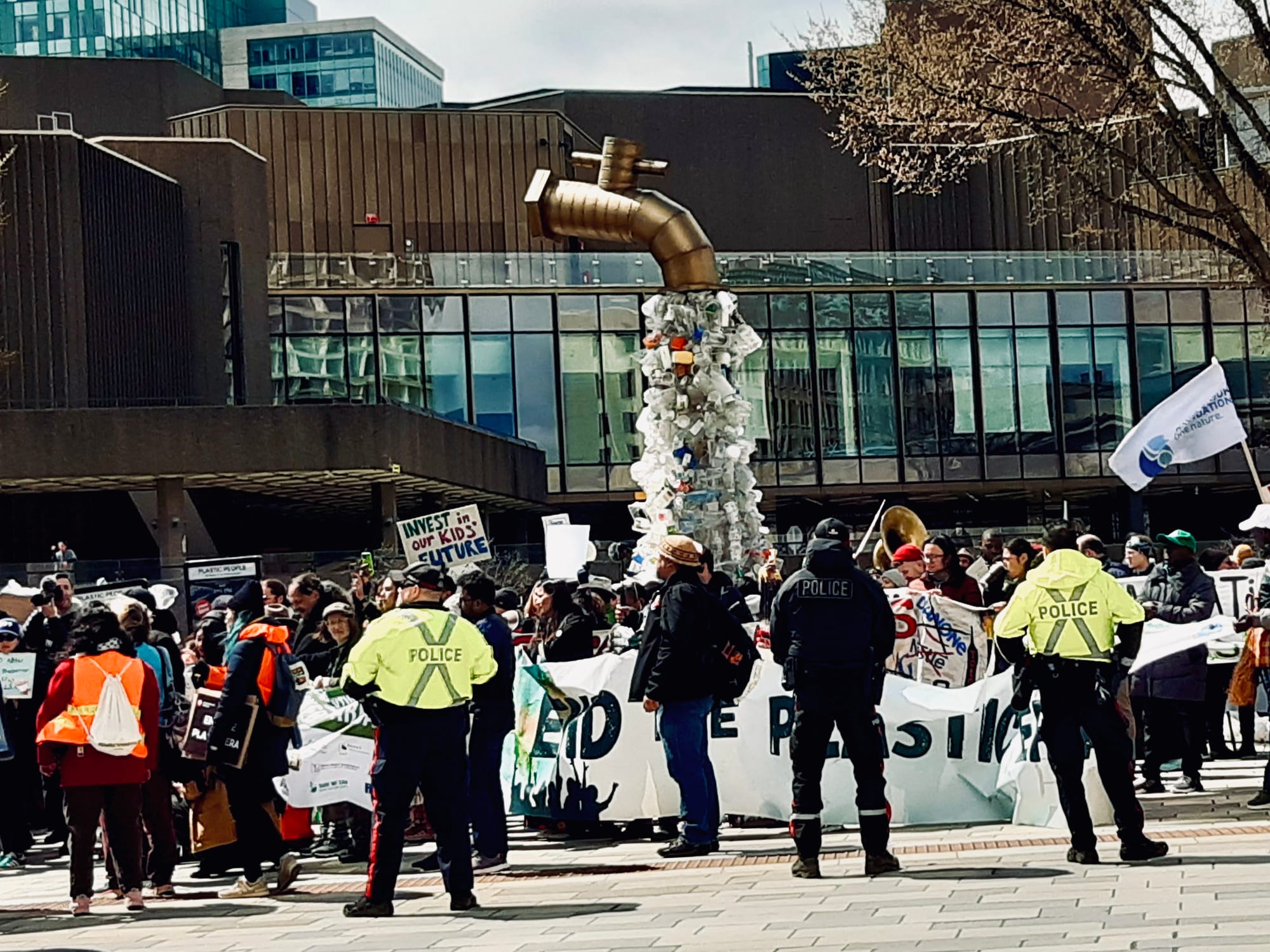 Police watch over a protest at the plastic treaty talks in Ottawa