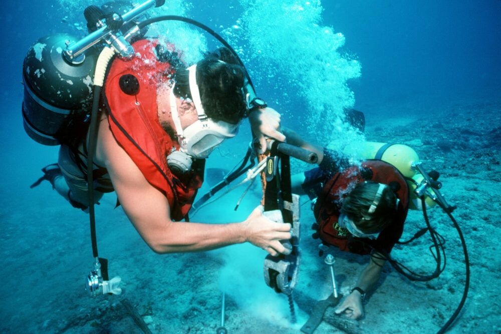 Divers repair an undersea cable at the U.S. Navy's Pacific Missile Range Facility