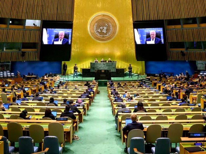 Palestinian President Mahmoud Abbas, on screens, addresses the U.N. General Assembly.